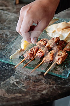 Thai spicy tender pork barbecue skewers with grill pineapple and Papadum crispy chips in glass plate