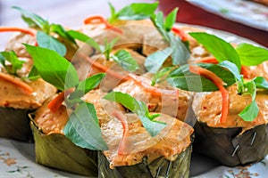 Thai steamed curry fish in banana leaf cups decorated with basil leaf, (Hor Mok Pla)