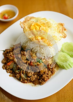 Thai stir fried basil with minced pork and fried egg eating with cooked rice