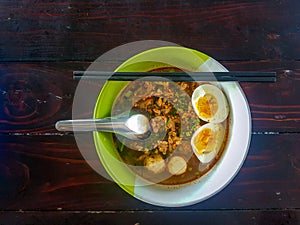 Thai style chopped pork noodle garnished with pork balls and half-cutted boiled egg