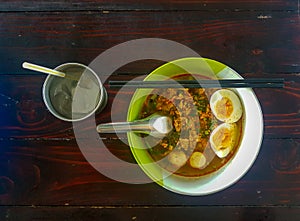 Thai style chopped pork noodle garnished with pork balls, half-cutted boiled egg photo