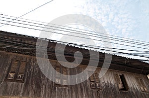 Thai style old traditional house with electrical wires on the top in cloudy day