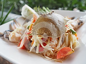 Thai style papaya spicy salad with raw blue crab.