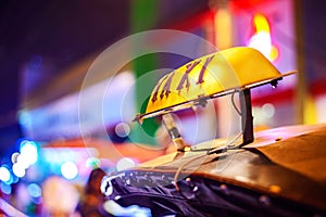 Thai Taxi (Tuk Tuk) sign with defocused lights blur