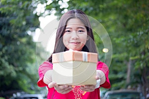 Thai teen beautiful girl in Chinese dress, happy new year and give gift, relax and smile.