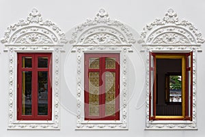Thai temple window with stucco decorations after restoration in Wat Thong Noppakun
