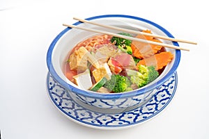 Thai Tofu Veggie dish in a traditional Thai bowl with chopsticks diagonally on top