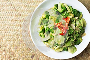 Thai traditional food stir fried broccoli (Pad pak) hot and spicy in white plate on Basketry background clean and delicious