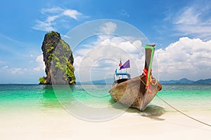 Thai traditional wooden longtail boat and beautiful sand beach
