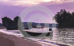 Thai traditional wooden longtail boats at the purple sunset in Krabi province. Thailand.