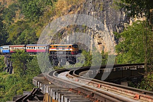 Thai trains running on death railways crossing kwai river in kan photo