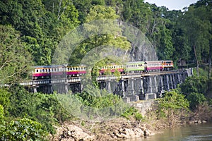 Thai trains running on death railways crossing kwai river in Kanchanaburi