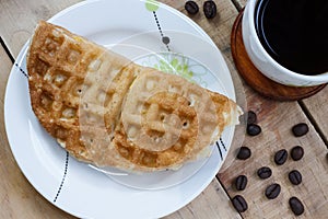 Thai waffle on white dish and coffee, Top view