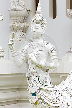 Thai white angel statue with lotus in temple