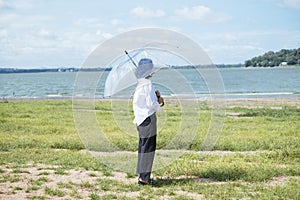 Thai woman holding transparency umbrella among nature