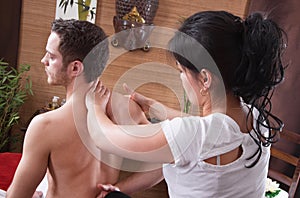 Thai woman making massage at a man in spa