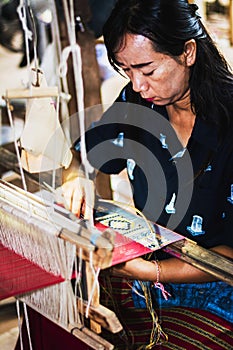 Thai woman making silk thread.