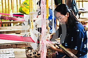 Thai woman making silk thread.