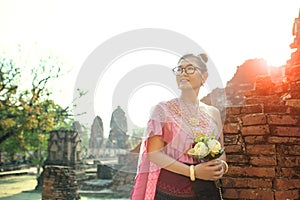 Thai woman toothy smiling face standing with pink lotus flower b
