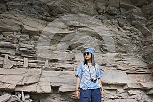 Thai women travel and posing at Rock art on cliffs at Pha Taem National Park in Ubon Ratchathani, Thailand