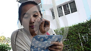 Thai woman use eyeliner pencil make up