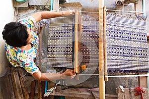 Thai woman weaving straw mat