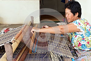 Thai woman weaving straw mat