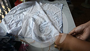 Thai woman working process fold bundle and sewing or arashi shibori on fabric