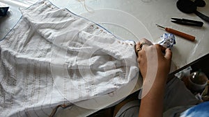 Thai woman working process fold bundle and sewing or arashi shibori on fabric