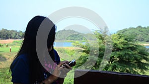 Thai women portrait and use mobile phone selfie at kaeng krachan dam