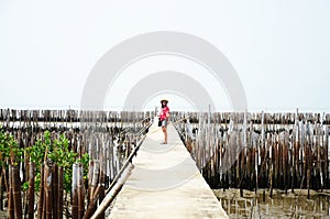 Thai women standing alone on the walkway bridge in Mangrove forest