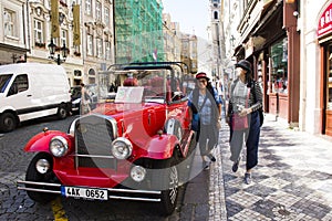 Thai women take photo with red retro car at old town near Charles Bridge