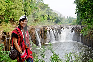 Thai women travel and posing for portrait at Tad Pha Suam waterfalls in Pakse