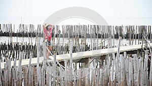 Thai women walking alone on the walkway bridge in Mangrove forest