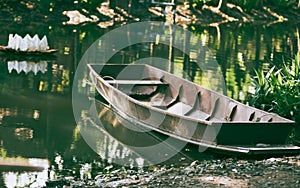 Thai wooden rowboat along riverside on natural light