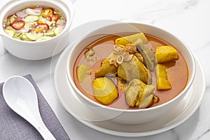 Thai yellow chicken curry with potatoes served with cucumber relish