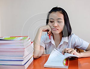 Thai young adult woman student in uniform reading a book