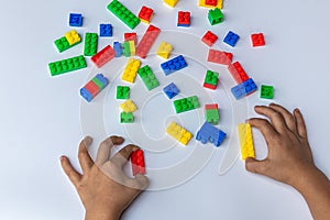 Thailand, bangkok. April 27, 2020. Children hands play with colorful lego blocks on white background.