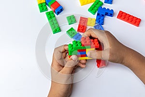Thailand, bangkok. April 28, 2020. Children hands play with colorful lego blocks on white background.