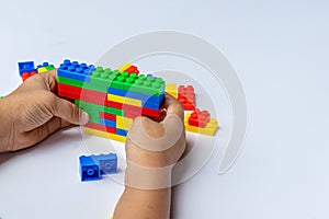 Thailand, bangkok. April 29, 2020. Children hands play with colorful lego blocks on white background.