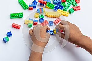 Thailand, bangkok. April 29, 2020. Children hands play with colorful lego blocks on white background.