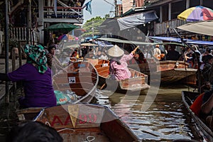 Thailand, Bangkok - 06 November 2018: Tourists in traditional wooden boat buying goods on Damnoen Saduak Floating Market