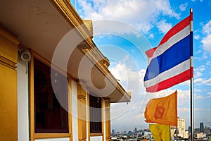 Thailand and Dharmachakra flags on the top of the phu khao thong or golden mountain of wat saket, or the golden mount temple.