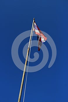 Thailand flag is waving with high pole with blue sky background. photo