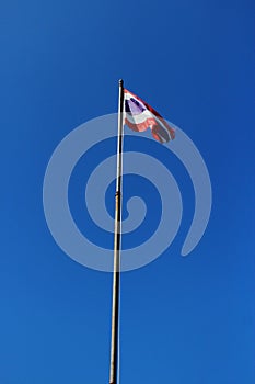 Thailand flag is waving with high pole with blue sky background. photo