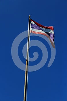 Thailand flag is waving with high pole with blue sky background. photo