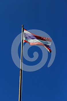 Thailand flag is waving with high pole with blue sky background. photo