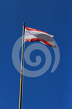 Thailand flag is waving with high pole with blue sky background. photo