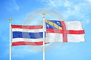 Thailand and Herm two flags on flagpoles and blue sky