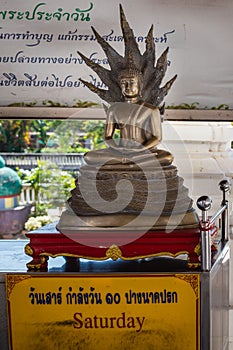 Thailand; Jan 2020: Statue of Buddha in Saturday position, seated in a full lotus position, protected by the Naga King, covered